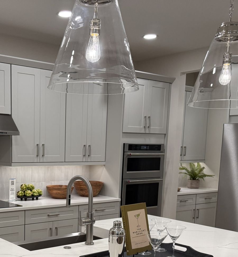 Model home kitchen with large quartz island and pendant lights at Summercrest